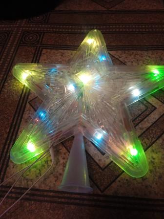 Звезда на елку светится мигает с гирляндой