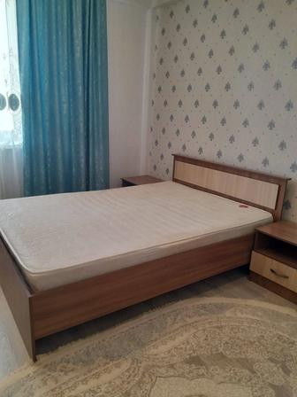 Двуспальная кровать с тумбочками.