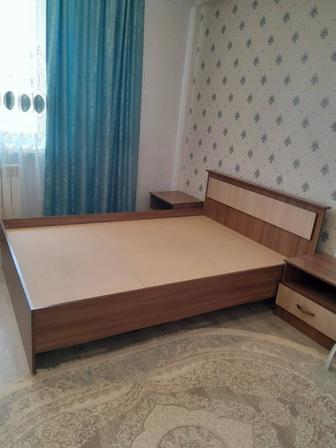 Двуспальная кровать с тумбочками.