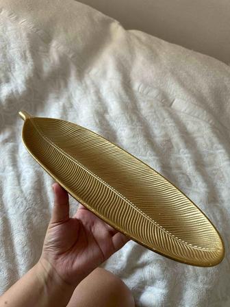 декоративный поднос в форме листа золотого цвета.